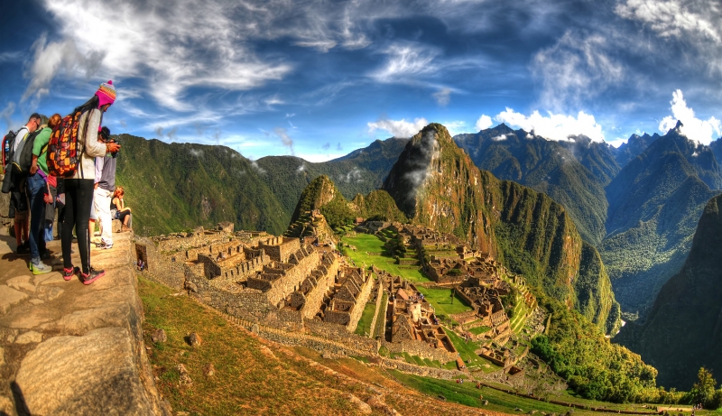 HDR image of tourists observing the wonder of Machu Picchu, the lost city of the Inca near Cusco, Peru.